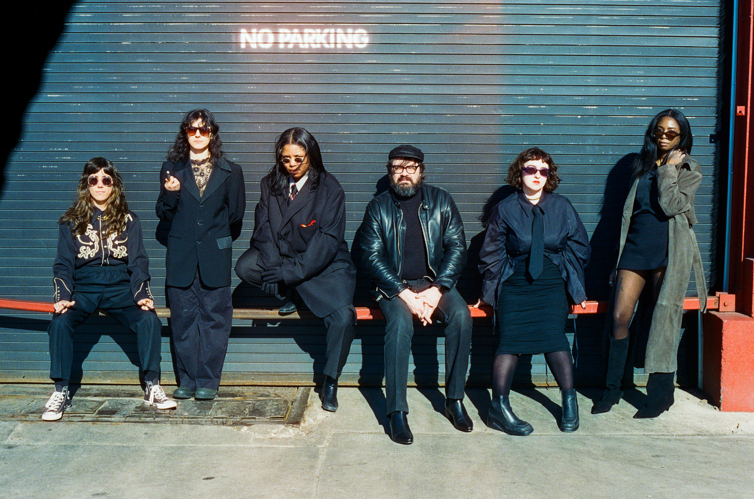 All 6 members of the rock band Mirror Mask leaning against a wall labeled No Parking